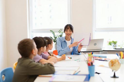 子どもたちに説明する先生 女性,女の子,男の子の写真素材