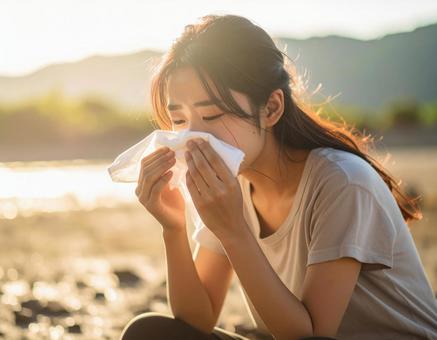 猛暑でしゃがみこむ女性の写真