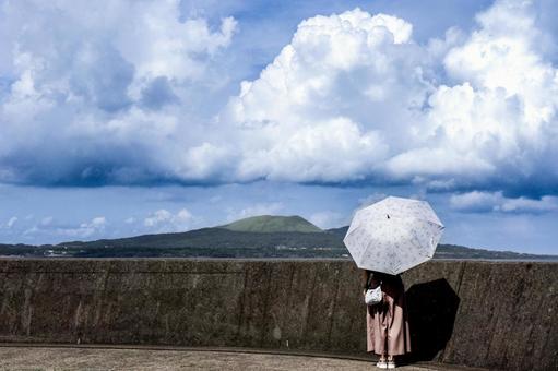 ＜素材＞夏の海沿いの防波堤を散策する女性 女性,青空,大空の写真素材