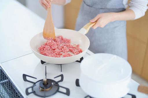 フライパンで挽き肉を炒める人の手元 フライパンで挽き肉を炒める人の手元 フライパン,持つ,炒めるの写真素材