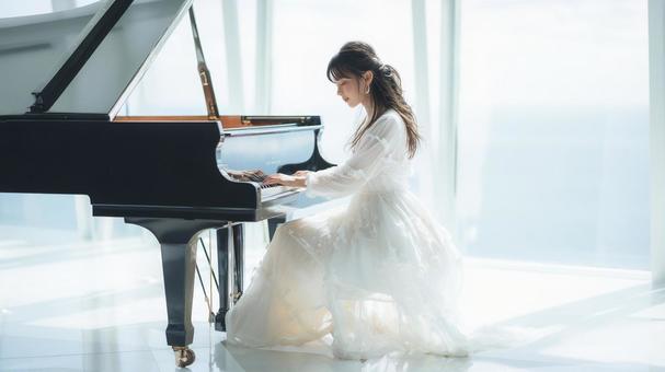 白いドレスを着てピアノを弾く女性 白いドレスを着てピアノを弾く女性の写真