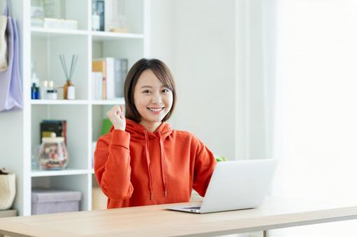 リビングでパオsコンを使う若い女性 リビングでパオsコンを使う若い女性 パソコン,女性,家の写真素材