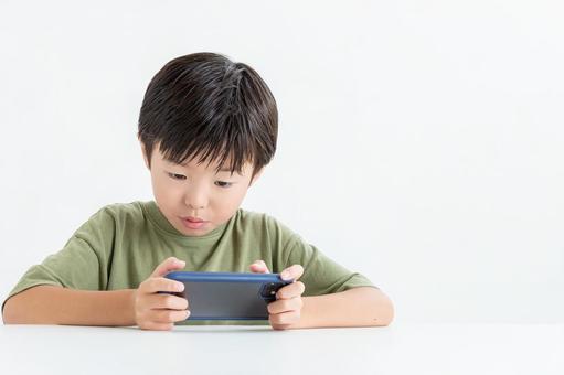 スマホに夢中な男の子 スマホに夢中な男の子の写真