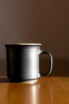 湯気立つコーヒーのマグカップ_縦の写真