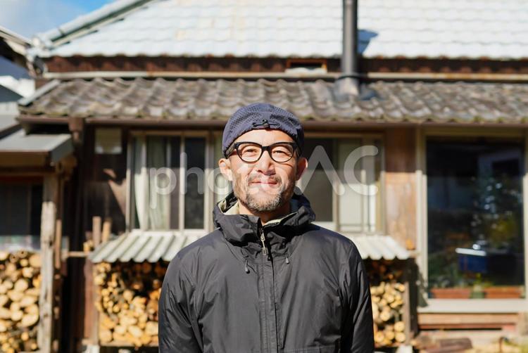 古民家の庭で笑顔の男性 笑顔,屋外,パーカーの写真素材
