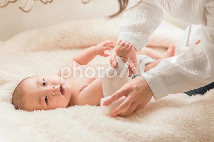 ベッドで寝る赤ちゃんに包帯を巻くママ 親子,赤ちゃん,怪我の写真素材