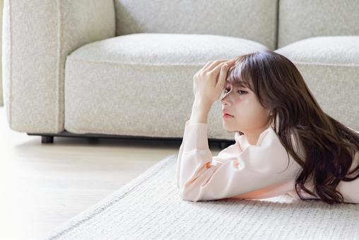 絨毯に寝そべる女性 絨毯に寝そべる女性 女性,リビング,頬杖の写真素材