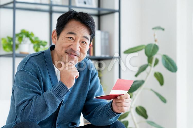 通帳を持つミドルの男性 通帳,銀行通帳,預金の写真素材