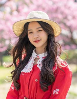 春・赤の彼女と桜の写真