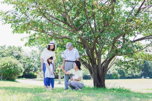 外で遊ぶ幸せな家族 子供,祖母,枝の写真素材