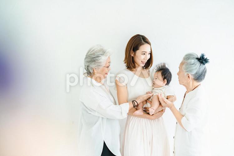 赤ちゃんを抱っこするシニア女性とお母さん  孫,おばあちゃん,シニアの写真素材