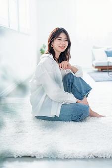 カーペットでリラックスする女性 女性,笑顔,リラックスの写真素材