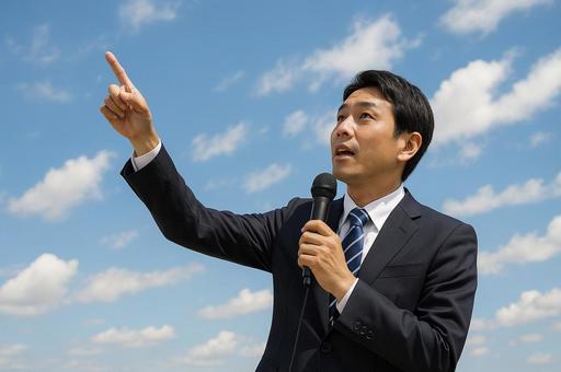 大空を見上げて話す男性の写真