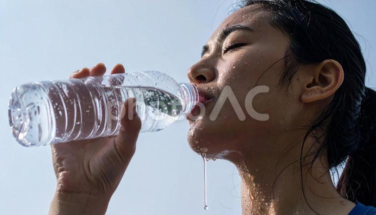 ミネラルウォーターを飲み水分補給する女性 水分補給,飲み物,水の写真素材