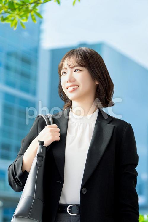 オフィス街を歩く笑顔の女性 女性,ビジネス,笑顔の写真素材