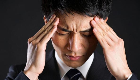 頭を抱えるビジネスマン 頭を抱えるビジネスマンの写真