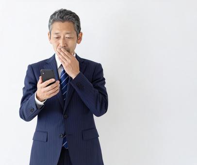 スマホ 50代 笑顔 悪い知らせ スマホ 50代 笑顔 悪い知らせ の写真
