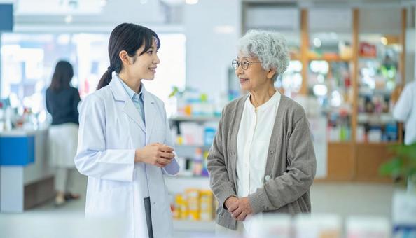 穏やかに話している薬剤師と高齢者 穏やかに話している薬剤師と高齢者の写真