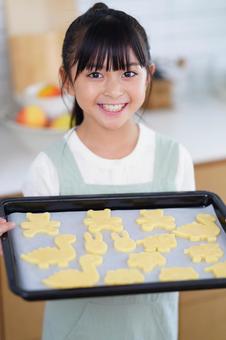 手作りクッキーをオーブンプレートに乗せた女の子 女の子,日本人,クッキーの写真素材