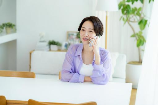 スマホで電話するミドル女性 スマホ,笑顔,女性の写真素材