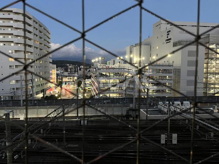 フェンス越しの金沢駅前の街並み フェンス,金網,金沢の写真素材