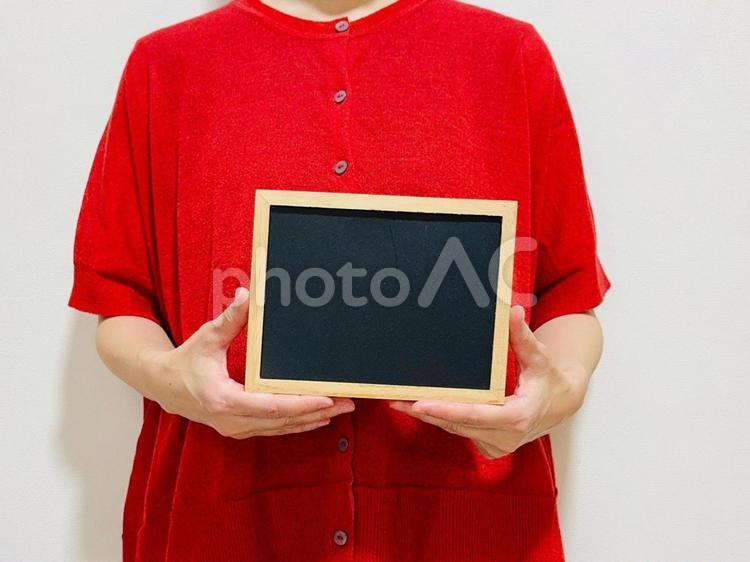 小さい黒板を持つ女性 黒板,女性,白紙の写真素材