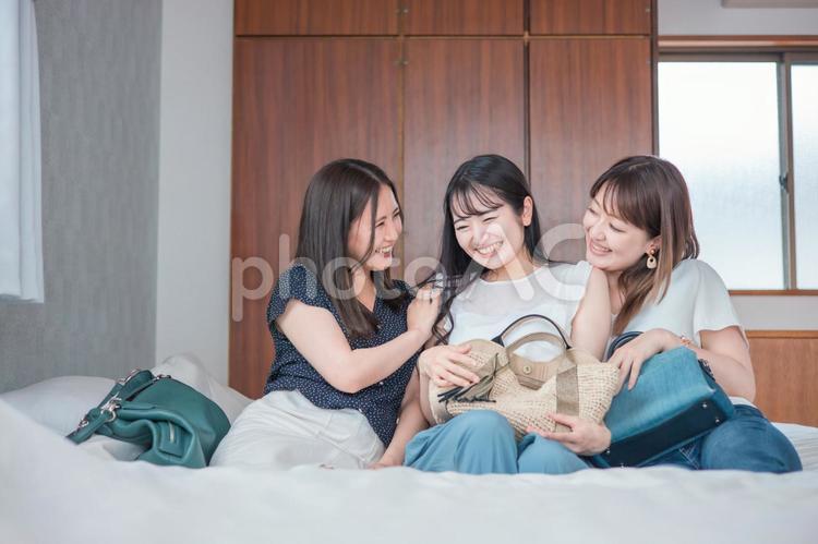旅行の宿泊先に着いた女性たち（ベッド） 旅行,旅,女子旅の写真素材
