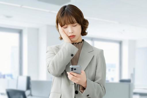 スマホを見て考える女性・ビジネスウーマン 女性,困る,考えるの写真素材