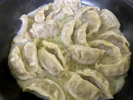 餃子をフライパンで焼く調理風景 餃子をフライパンで焼く調理風景 餃子,焼き餃子,フライパンの写真素材