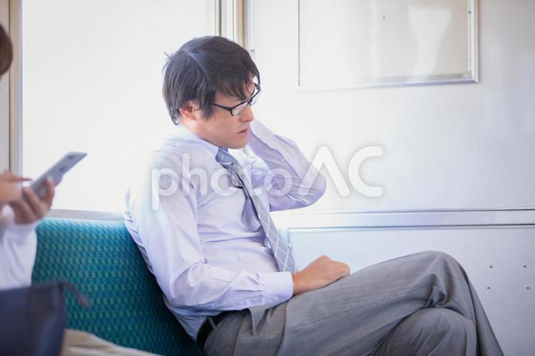 電車に乗る男性 電車,肩こり,サラリーマンの写真素材
