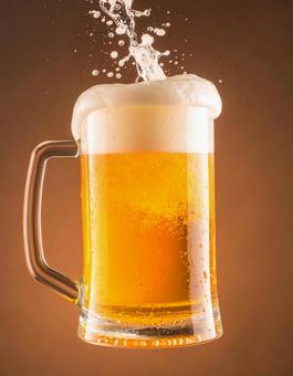 泡が飛び散るビールジョッキ 泡が飛び散るビールジョッキの写真