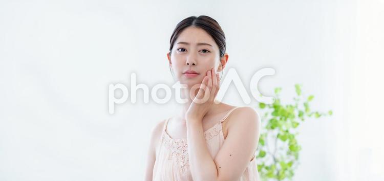 頬に手を当てているスキンケアイメージ 肌トラブル,スキンケア,美容の写真素材