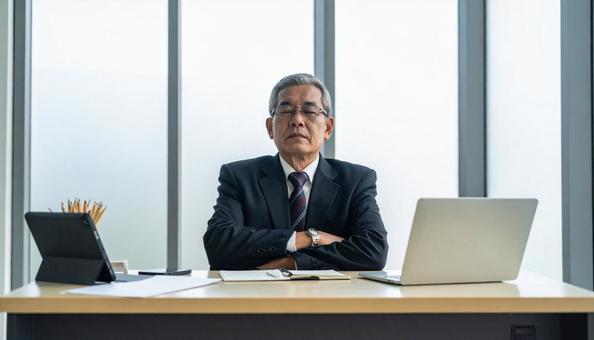 経営不振に腕を組んで悩む中小企業の社長 経営不振に腕を組んで悩む中小企業の社長の写真
