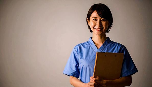 ファイルを抱える笑顔の日本人女性看護師 ファイルを抱える笑顔の日本人女性看護師の写真