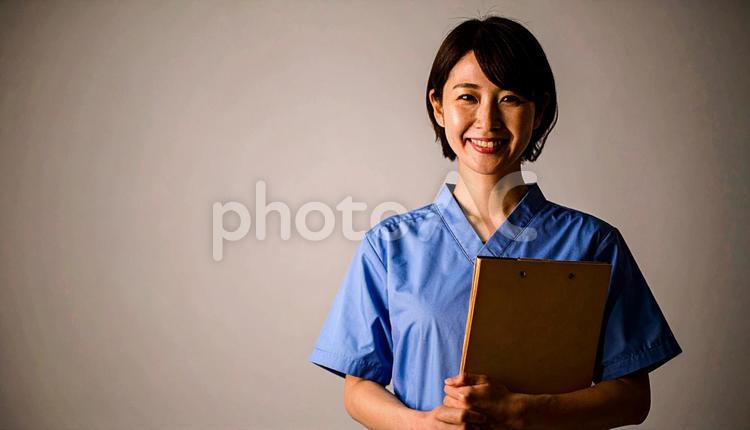 ファイルを抱える笑顔の日本人女性看護師 看護士,若い,白衣の写真素材