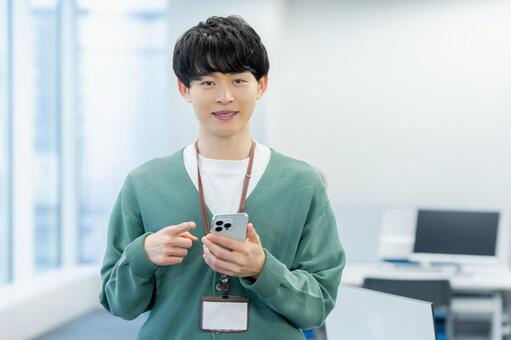 オフィスでスマホを使うビジネスマン スマホ,ビジネスマン,笑顔の写真素材