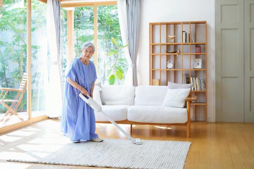 リビングの掃除をする高齢女性 女性,掃除,掃除機の写真素材