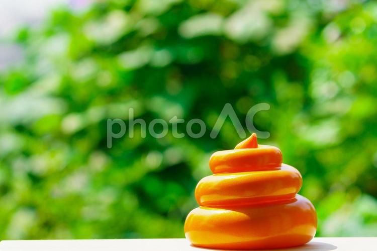 緑ぼかし背景と大便 うんこ,うんち,健康の写真素材