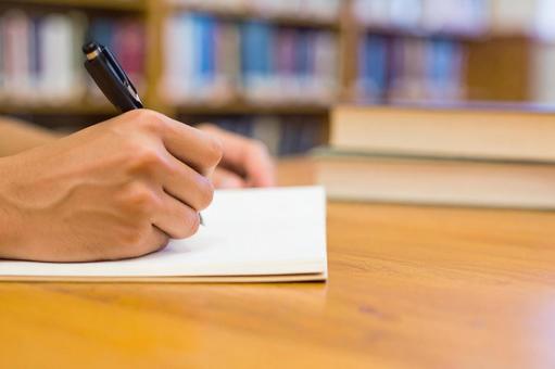 ノートにメモをとる手 ノートにメモをとる手の写真