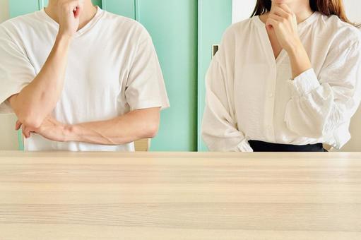 リビングで悩む男女のカップル リビングで悩む男女のカップルの写真