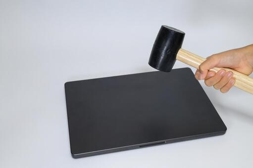 ノートパソコンをハンマーで叩く瞬間 ノートパソコン,破壊,ハンマーの写真素材