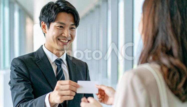 笑顔で名刺を差し出す男性社員 ビジネス,名刺,名刺交換の写真素材