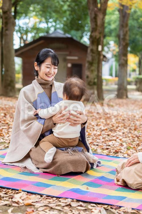 公園で赤ちゃんと抱っこしてママ友と話す女性 親子,赤ちゃん,子育ての写真素材