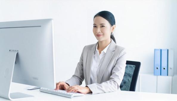 オフィスでパソコン使用した仕事をする女性 オフィスでパソコン使用した仕事をする女性の写真
