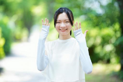 女性が手を挙げて笑顔を見せるの写真