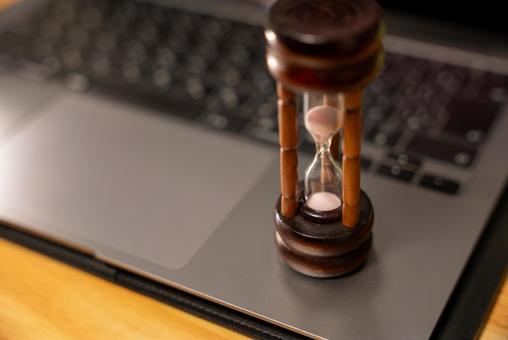 デスク上の砂時計とPC 砂時計,時間,時の流れの写真素材