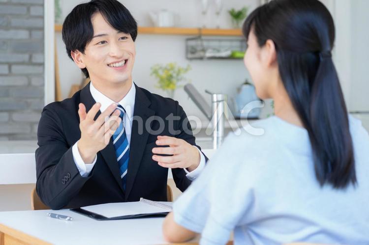 リビングで女性と商談をするビジネスマン 営業,金融,保険の写真素材