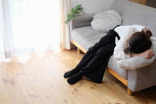 ソファーで休む40代女性 不安,失敗,苦しいの写真素材