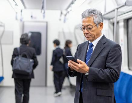 ビジネスシーン・地下鉄出張、スマホを見る ビジネスシーン・地下鉄出張、スマホを見るの写真