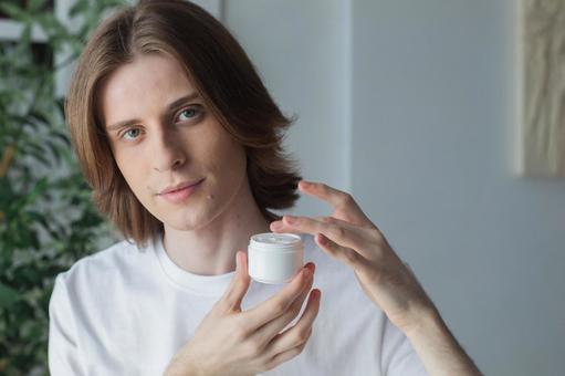 保湿クリームを手に取るカメラ目線の男性 男性,外国人,欧米人の写真素材